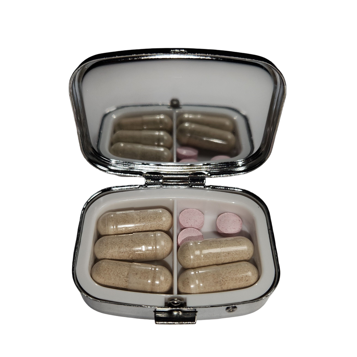 Open decorative pill organizer with built in- mirror, two compartments, and secure clasp, showing how pills can be stored.
