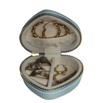 Open blue heart-shaped jewelry organizer showing rings and earrings inside its soft-lined compartments.