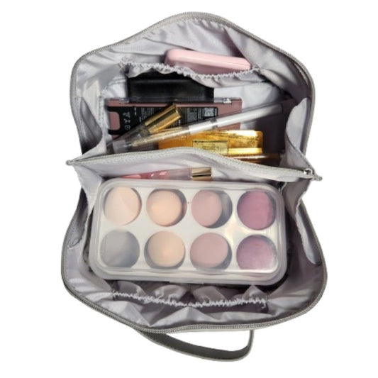 Silver metallic makeup bag open with beauty essentials inside